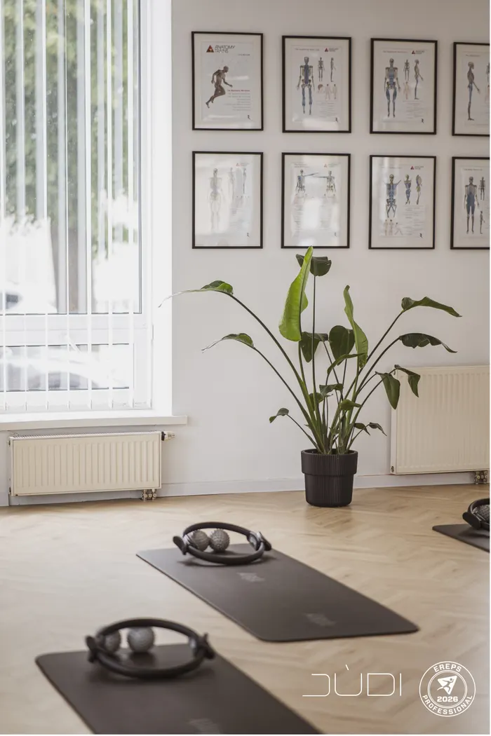 Šviesi JÙDI studijos salė su kilimėliais ir Pilates žiedais